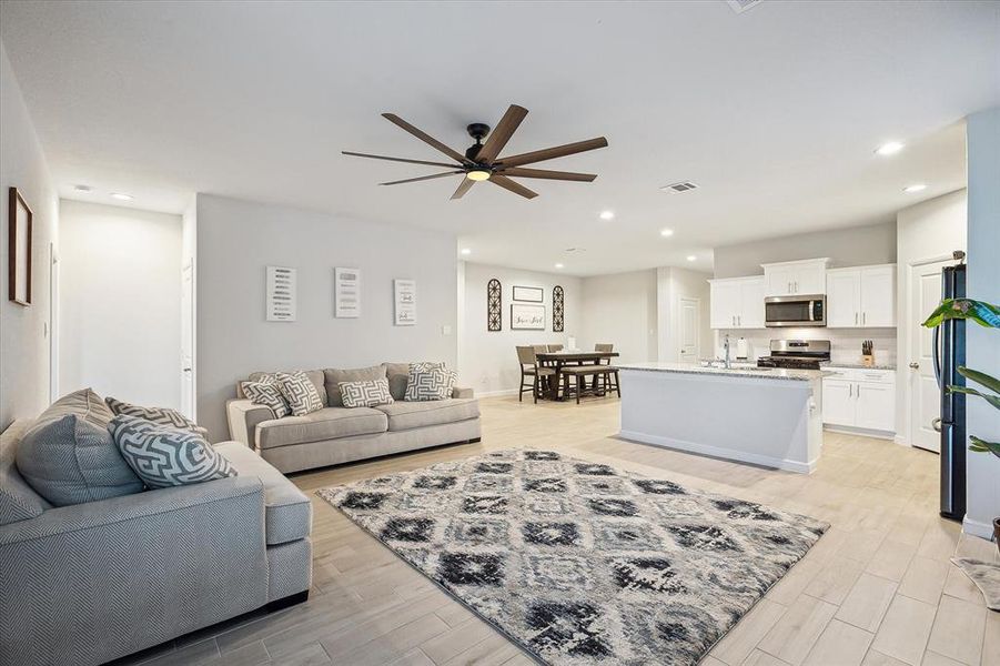 Living room featuring ceiling fan, light hardwood / wood-style flooring, and sink Living room featuring ceiling fan, light hardwood / wood-style flooring, and sink