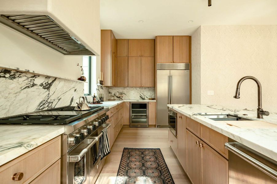 Kitchen featuring 48" Wolf stove, 42" Subzero building in fridge and beverage cooler, microwave