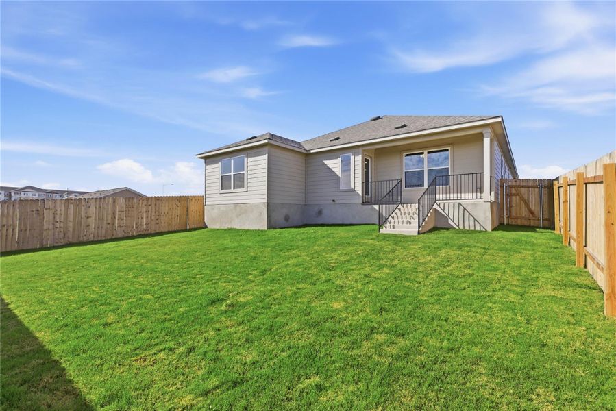 Rear view of house with a fenced backyard and a gate