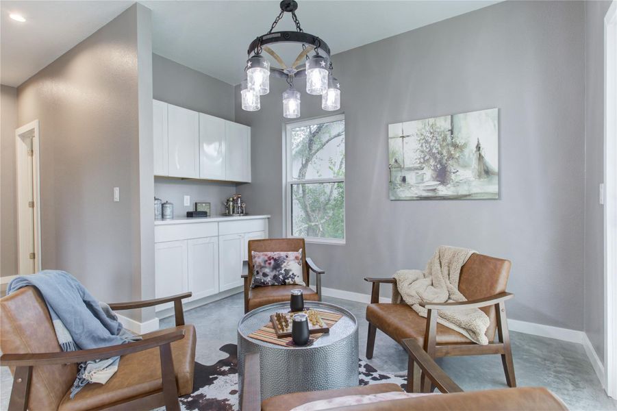 Sitting area featuring baseboards and a chandelier