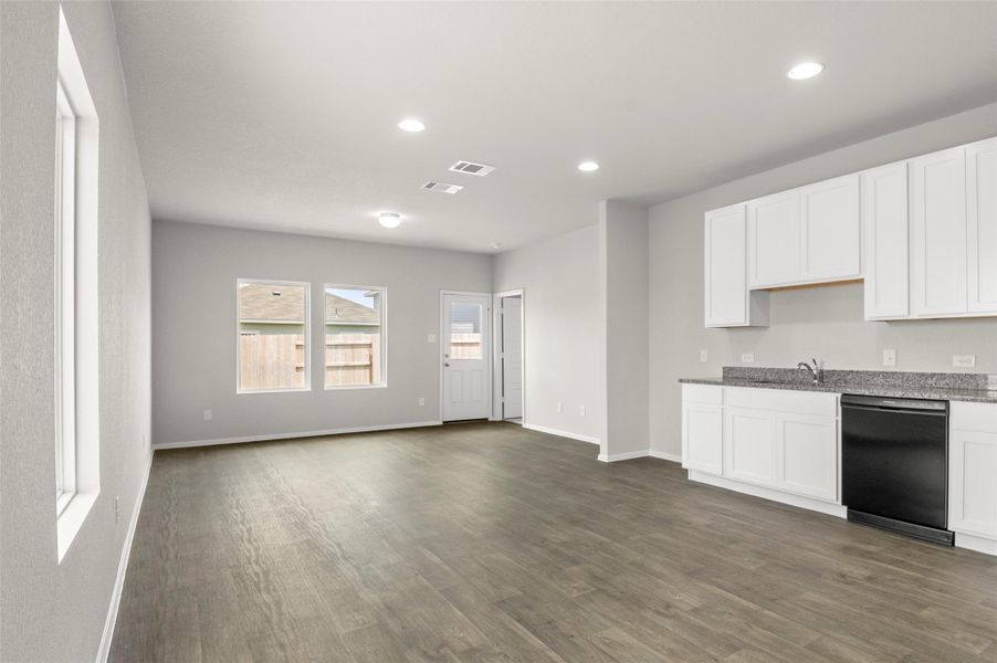 Kitchen featuring dishwasher, dark wood finished floors, white cabinets, light stone counters, and recessed lighting Kitchen featuring dishwasher, dark wood finished floors, white cabinets, light stone counters, and recessed lighting