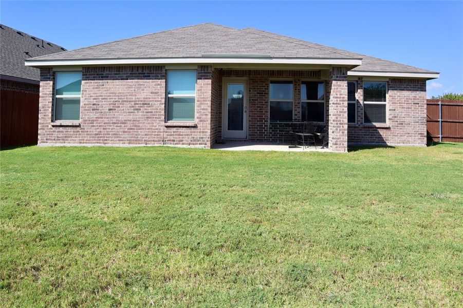 Back of property featuring a patio area, brick siding, and roof with shingles Back of property featuring a patio area, brick siding, and roof with shingles