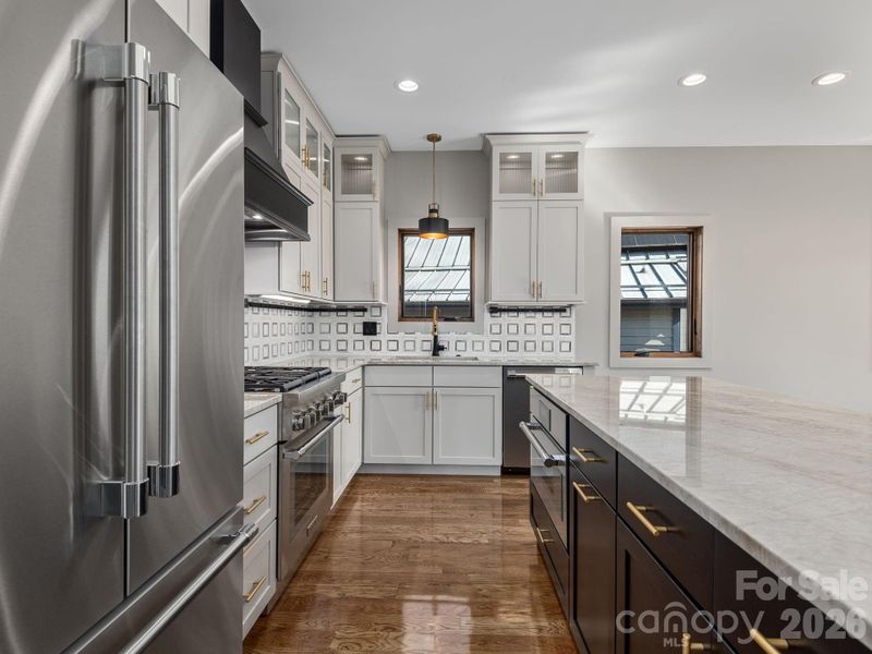 Representative photo from 50 Verde Drive showing the builder’s quality of construction and finish level, including granite countertops, Thermador appliances, Wolf Home Products cabinetry, tile backsplash, and an oversized center island.