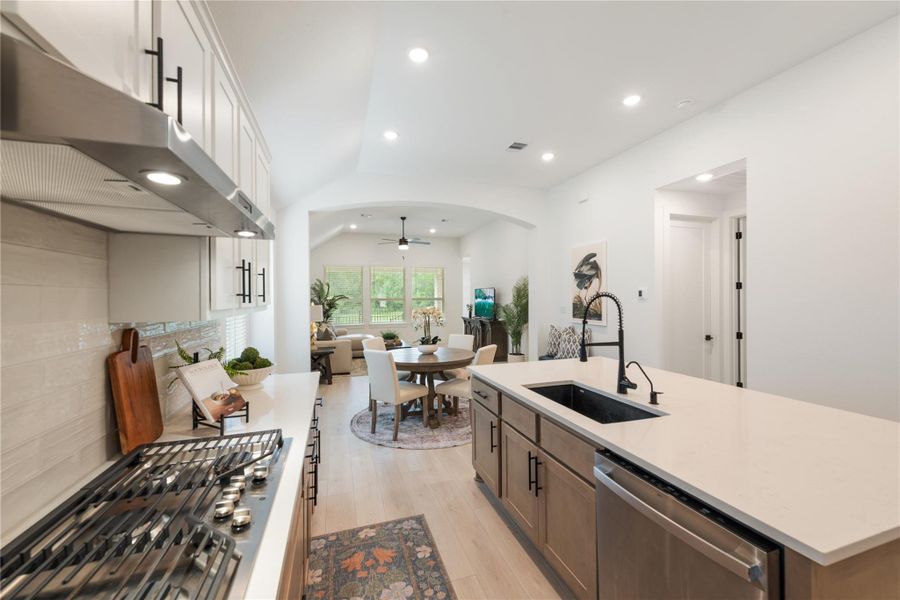 An open-concept living area with a well-appointed kitchen flows into a luminous dining and gathering space. An open-concept living area with a well-appointed kitchen flows into a luminous dining and gathering space.
