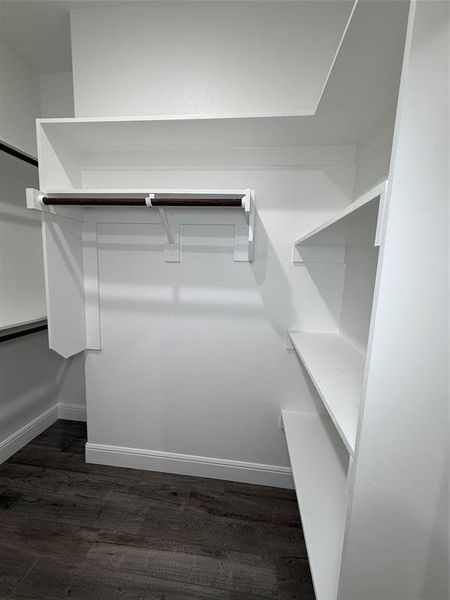Custom closet organization system featuring white shelving and a dark wood-finish hanging rod Custom closet organization system featuring white shelving and a dark wood-finish hanging rod