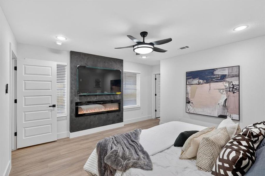 Accent wall featuring a built-in electric fireplace and mounted television