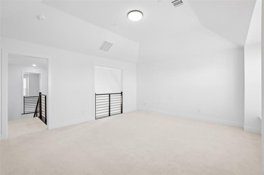 Bonus room with light colored carpet and vaulted ceiling Bonus room with light colored carpet and vaulted ceiling