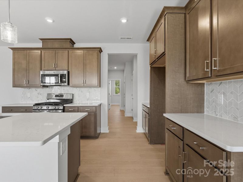 Modern Stained, Wood-Toned Cabinets Bring Warmth to the Space.