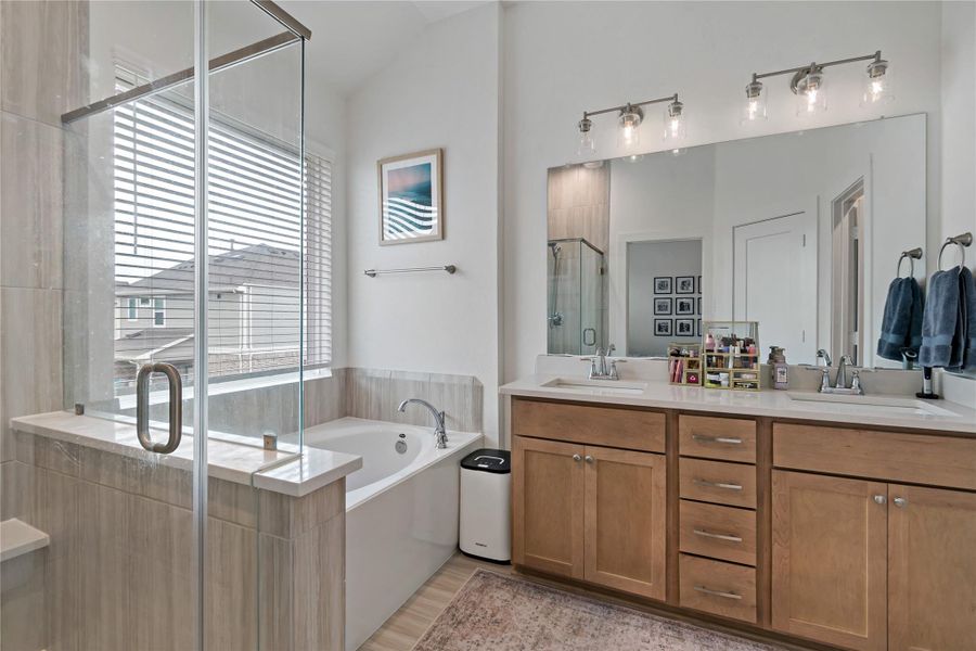 Elegant bathroom featuring a spacious glass-enclosed shower, a luxurious soaking tub, and a double vanity with ample storage, all enhanced by natural light and modern fixtures. Elegant bathroom featuring a spacious glass-enclosed shower, a luxurious soaking tub, and a double vanity with ample storage, all enhanced by natural light and modern fixtures.