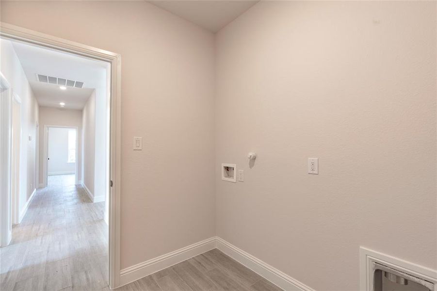 Laundry room with hookup for a washing machine, light hardwood / wood-style flooring, and gas dryer hookup