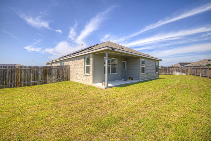 A spacious yard with a covered patio, perfect for outdoor relaxation.