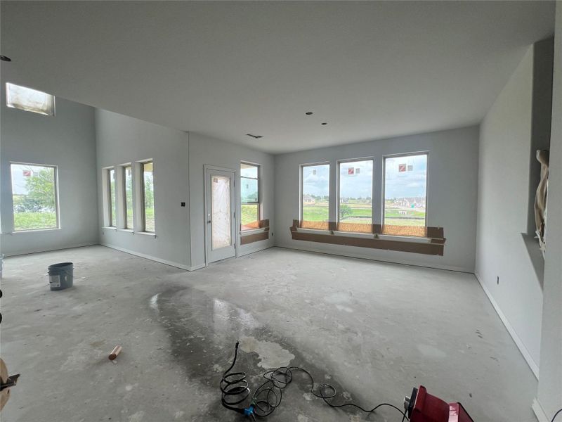 Unfurnished living room featuring unfinished concrete flooring and baseboards