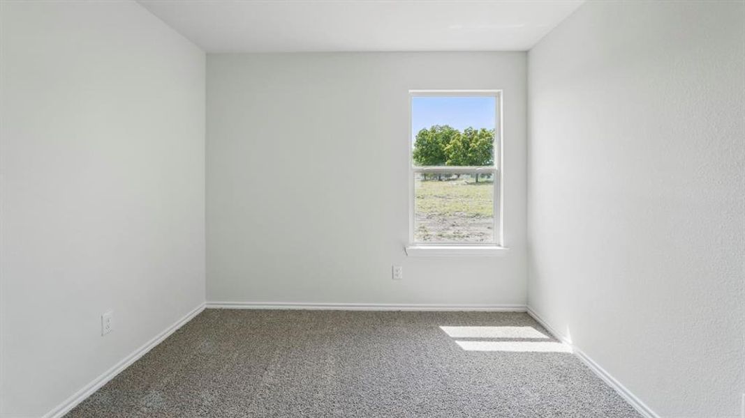 Carpeted spare room with baseboards