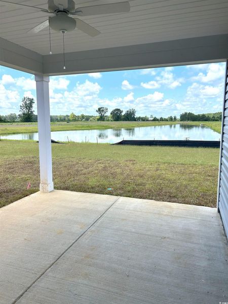 View of patio featuring a water view and ceiling fan