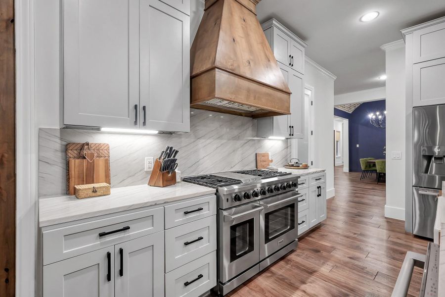 Experience the ultimate outdoor oasis with this side patio, featuring a high-end kitchen equipped with an Egg Smoker, gas grill, and beverage cooler. Conveniently located just outside the indoor kitchen.