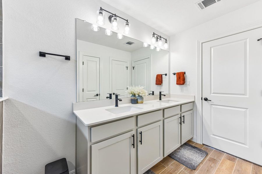 Double vanity with sleek fixtures offers ample counter space in this well-appointed bathroom.