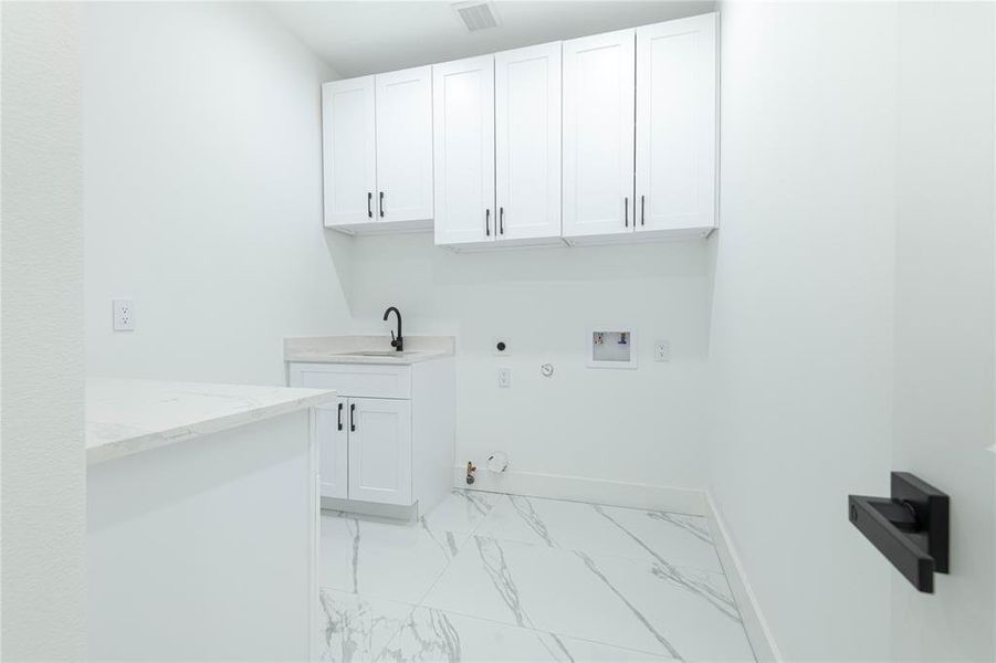 Laundry with cabinets and sink