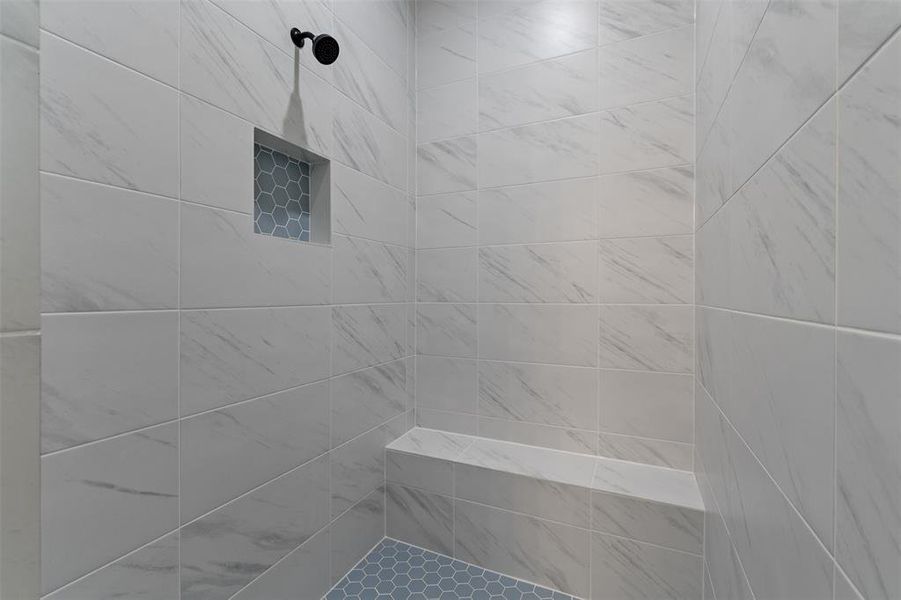 Primary Marble Shower includes a cubby for toiletries and a Bench! Notice the fine details in the cubby and on the floor of the shower, a touch of blue grey...