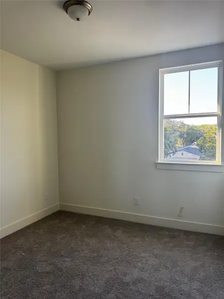 Unfurnished room featuring dark colored carpet and a textured ceiling Unfurnished room featuring dark colored carpet and a textured ceiling