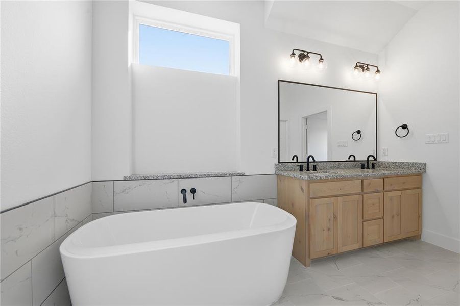 Full bath with double vanity, light marble finish floors, and a freestanding tub Full bath with double vanity, light marble finish floors, and a freestanding tub