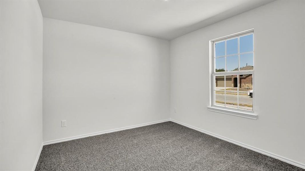 Neutral interior with white walls, gray carpet, and a large window providing ample natural light