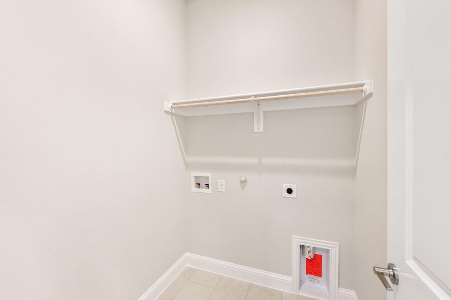 Laundry room with wall-mounted shelf, washer and dryer hookups, and gas connection on white walls Laundry room with wall-mounted shelf, washer and dryer hookups, and gas connection on white walls
