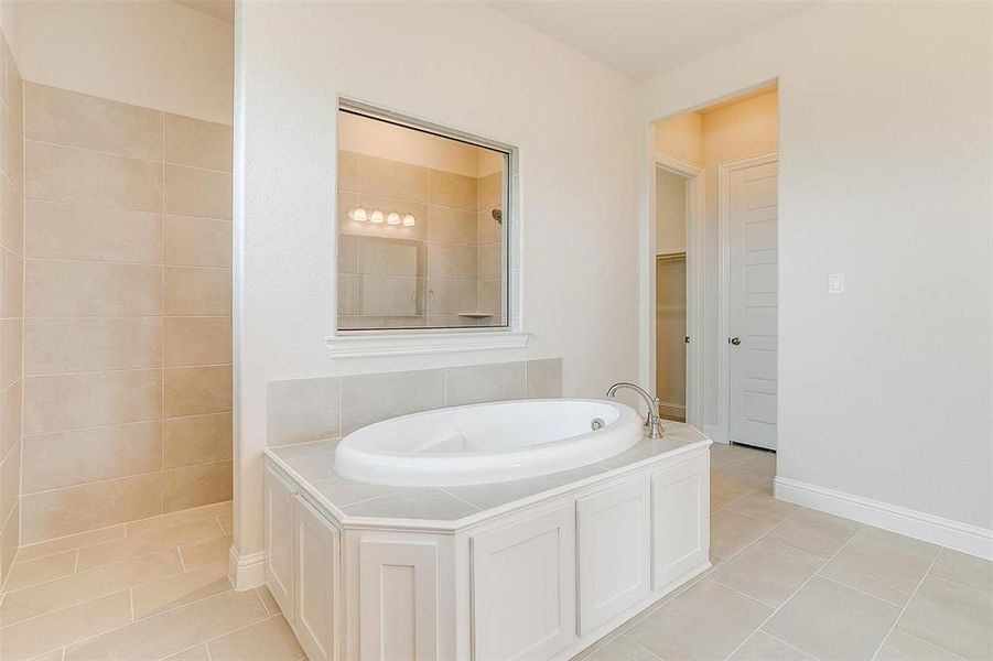 Bathroom featuring tile patterned flooring and a bath