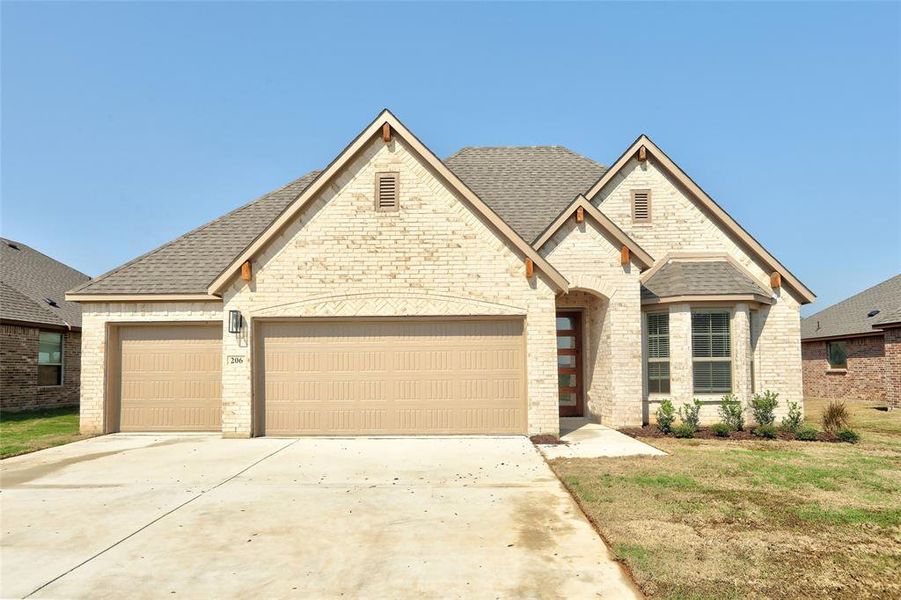 French provincial home featuring roof with shingles, driveway, a garage, and brick siding French provincial home featuring roof with shingles, driveway, a garage, and brick siding