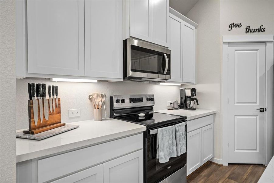 Your kitchen noting the range and microwave.  Plenty of cabinet and work space. An inviting space for cooking and gathering.