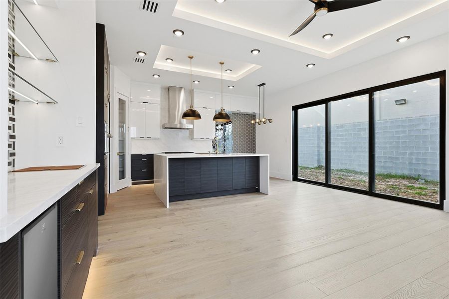 Same floorplan - different finishes. The open-concept living area boasts a large kitchen island with waterfall edges and massive sliding glass doors that lead to the backyard.