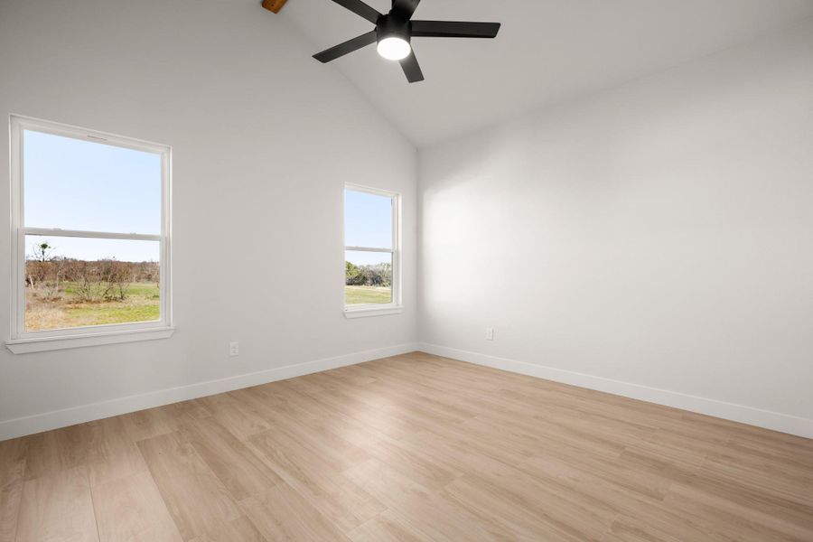 Unfurnished room with lofted ceiling, light wood finished floors, and ceiling fan