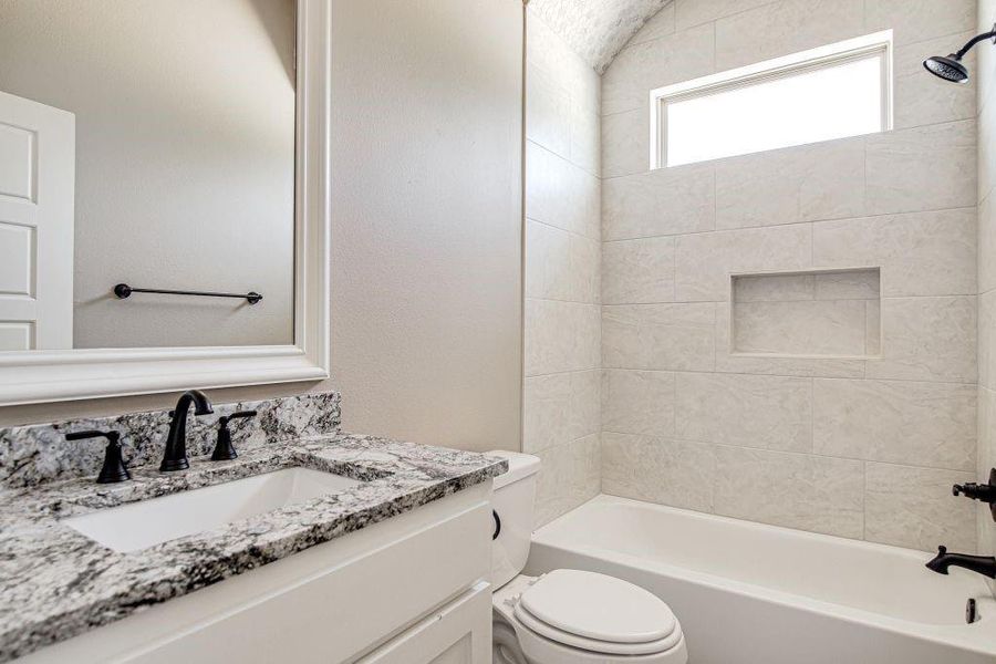 Full bathroom with vanity, toilet, and tiled shower / bath