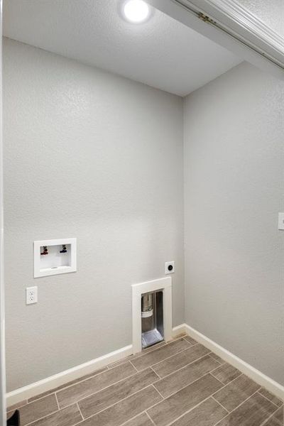 Laundry room with wood finish floors, hookup for an electric dryer, and hookup for a washing machine Laundry room with wood finish floors, hookup for an electric dryer, and hookup for a washing machine