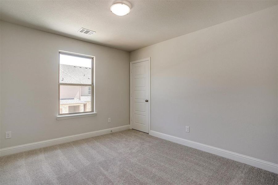 Spare room featuring baseboards and light carpet