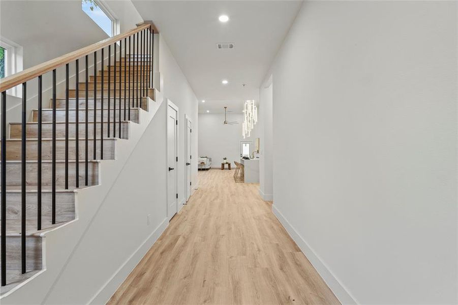 Hall with wood finished floors, stairs, recessed lighting, and baseboards Hall with wood finished floors, stairs, recessed lighting, and baseboards