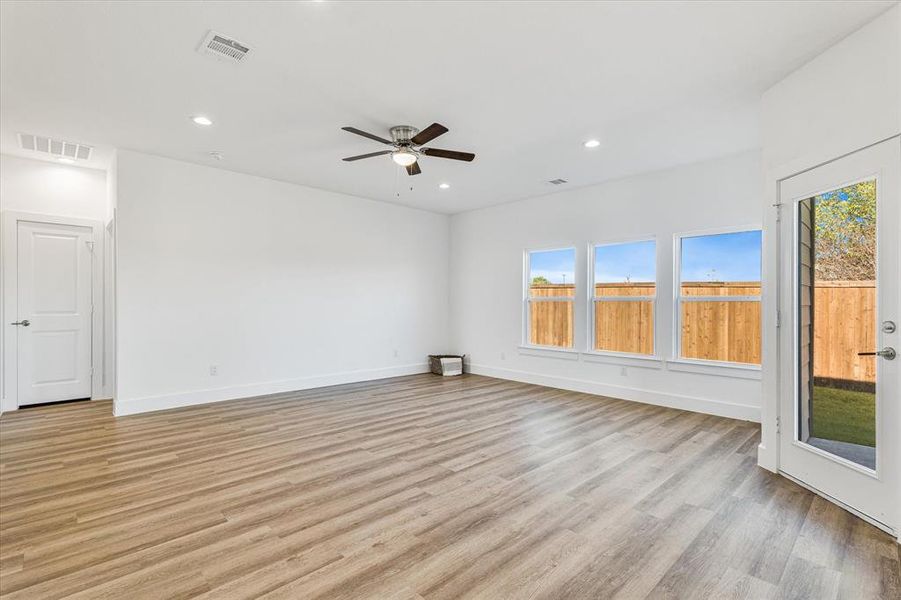 Living room with ceiling fan and light hardwood / wood-style floors Living room with ceiling fan and light hardwood / wood-style floors