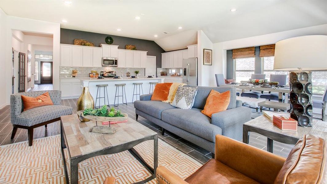 Living area featuring healthy amount of natural light, vaulted ceiling, recessed lighting, and wood finish floors Living area featuring healthy amount of natural light, vaulted ceiling, recessed lighting, and wood finish floors