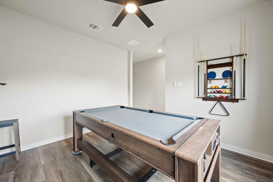 Smooth wood-look flooring and clean neutral walls anchor this versatile recreation room. Smooth wood-look flooring and clean neutral walls anchor this versatile recreation room.