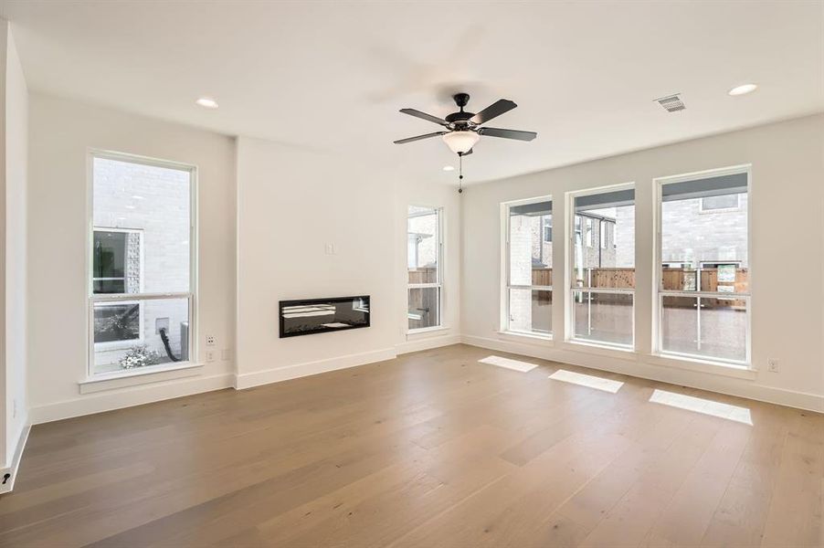 Unfurnished living room featuring hardwood / wood-style flooring and ceiling fan