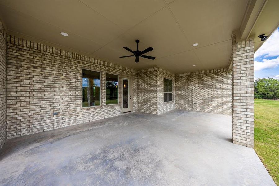 Expansive covered patio featuring a full brick exterior, a ceiling fan, recessed lighting, and a concrete slab