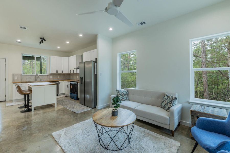 Open concept living area featuring polished concrete flooring, recessed lighting, and a ceiling fan Open concept living area featuring polished concrete flooring, recessed lighting, and a ceiling fan