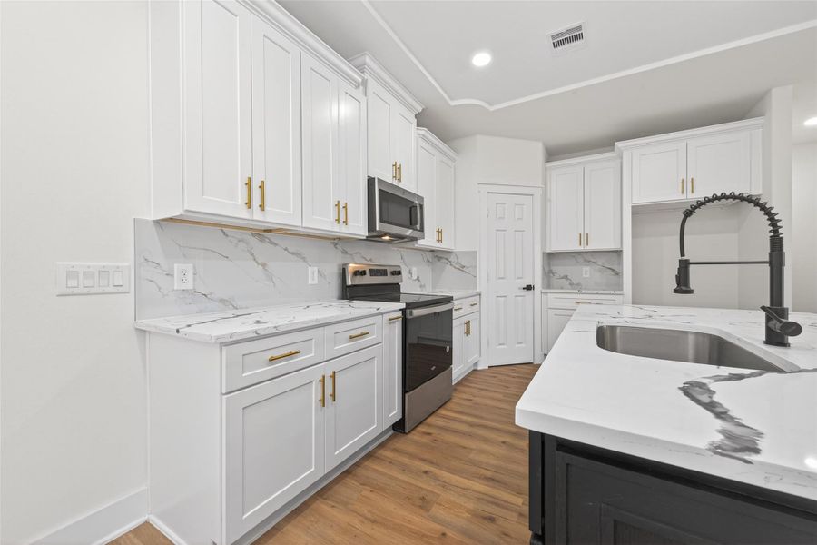 Modern kitchen with abundant cabinetry, large center island, and generous counter space.