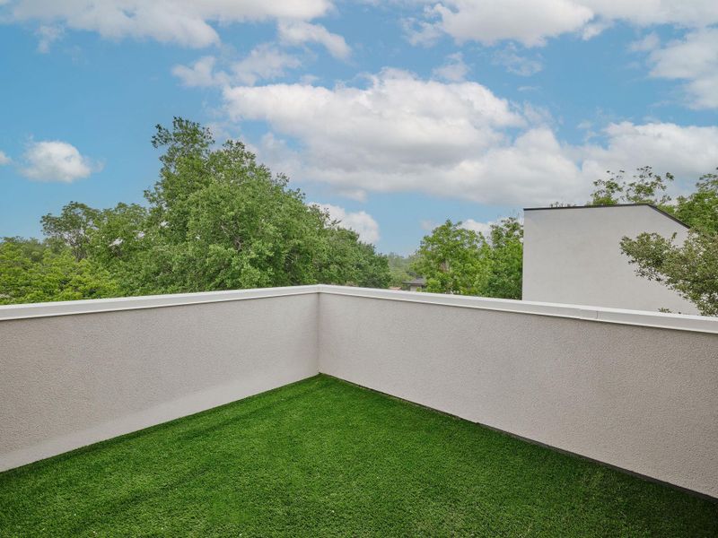Rooftop patio with artificial turf flooring and textured stucco walls