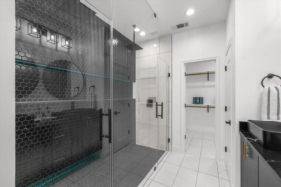 Full bath with vanity, a spacious closet, a stall shower, and recessed lighting