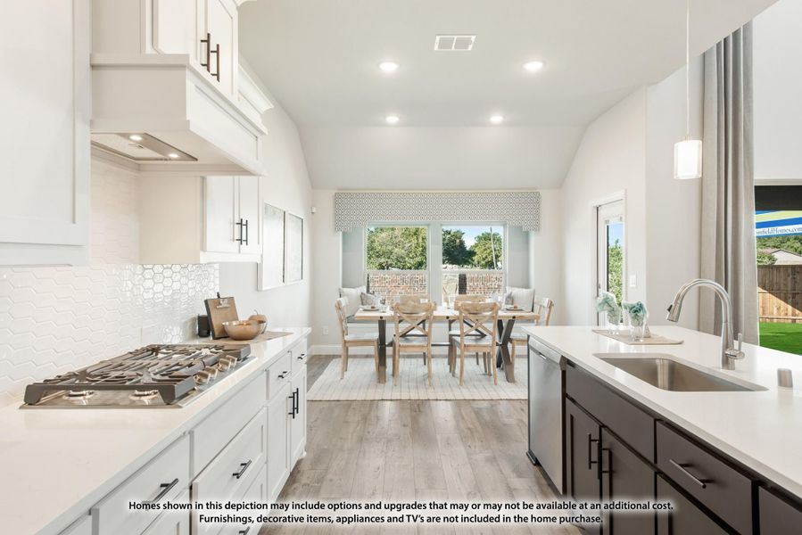 Open kitchen with white cabinets, gas cooktop, white tile backsplash, and dining area with wood floors beyond.