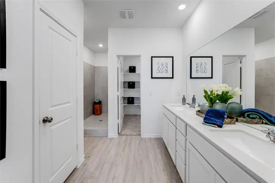 Bathroom with light wood-style floors, double vanity, a shower stall, and recessed lighting