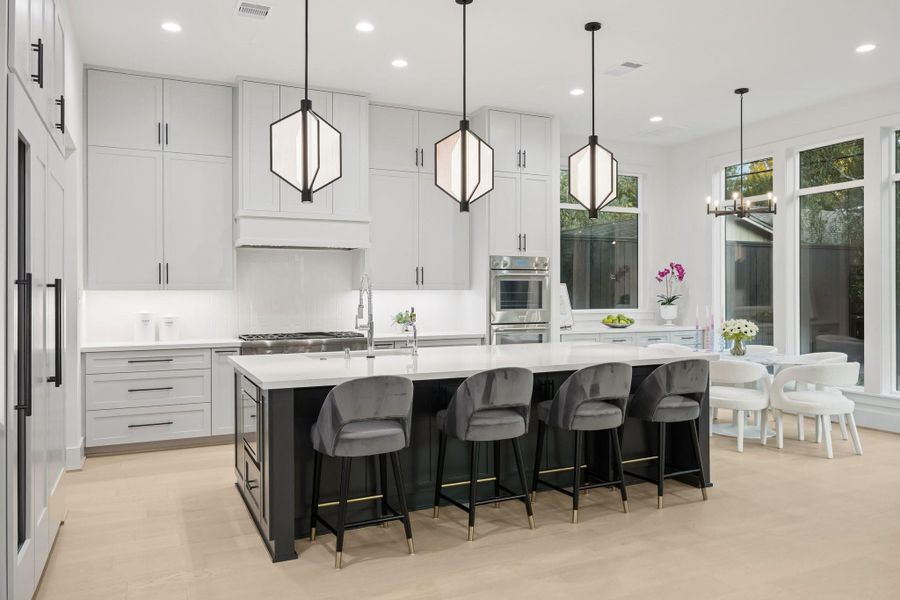 Island Kitchen with Breakfast Bar Seating, three pendent lights. There is an Incredible Appliance Package Including: Thermador Slide-In Range with 6 Burners, Griddle and Double Ovens. There is also a Hood with a Thermador Stainless Steel Liner, a Thermador Drawer Microwave, Thermador Panel Ready Built-In Dishwasher. Also included is a Thermador Panel Ready Refrigerator/Freezer plus a Wine Refrigerator.