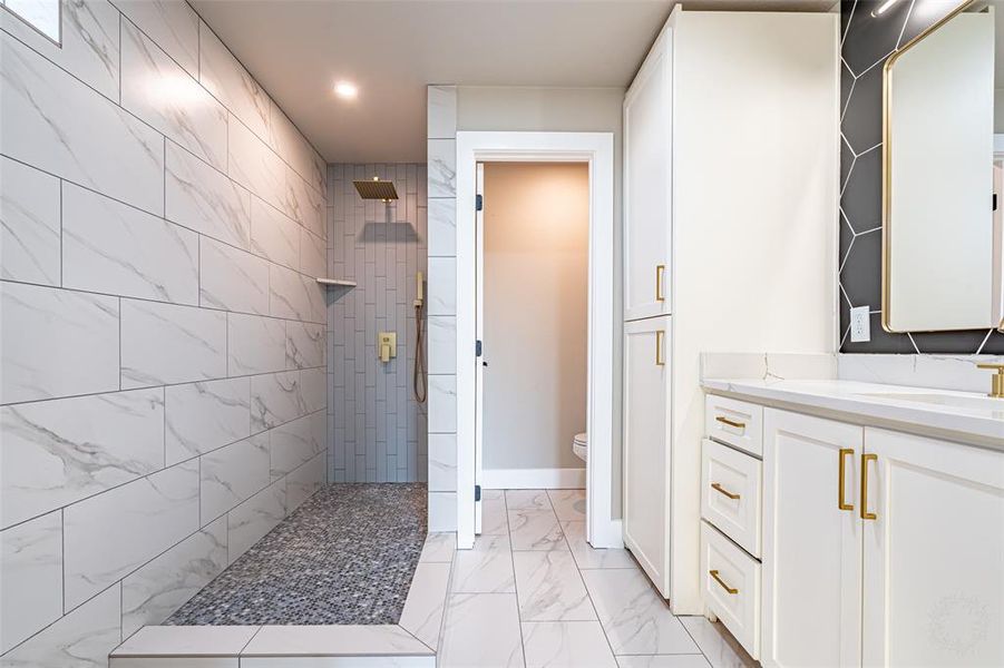 Bathroom featuring walk in shower, vanity, light marble finish floors, and recessed lighting Bathroom featuring walk in shower, vanity, light marble finish floors, and recessed lighting
