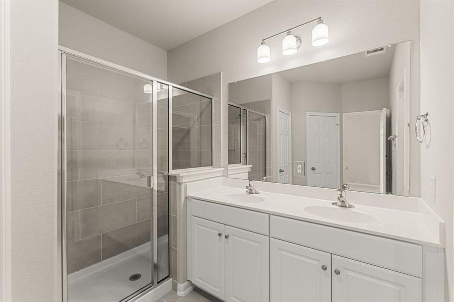 The en-suite bathroom offers a spa-like atmosphere with its elegant design, high end finishes, and tasteful lighting, creating a retreat within your own home.