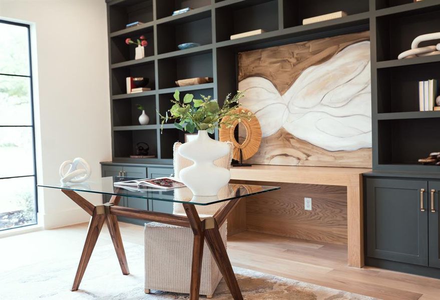 Home office featuring built in features and light hardwood / wood-style flooring